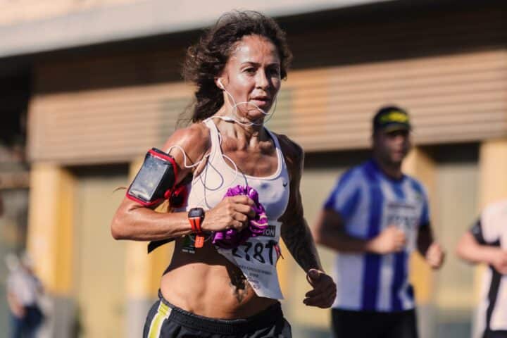 A runner wearing a red armband that carries her mobile phone. 