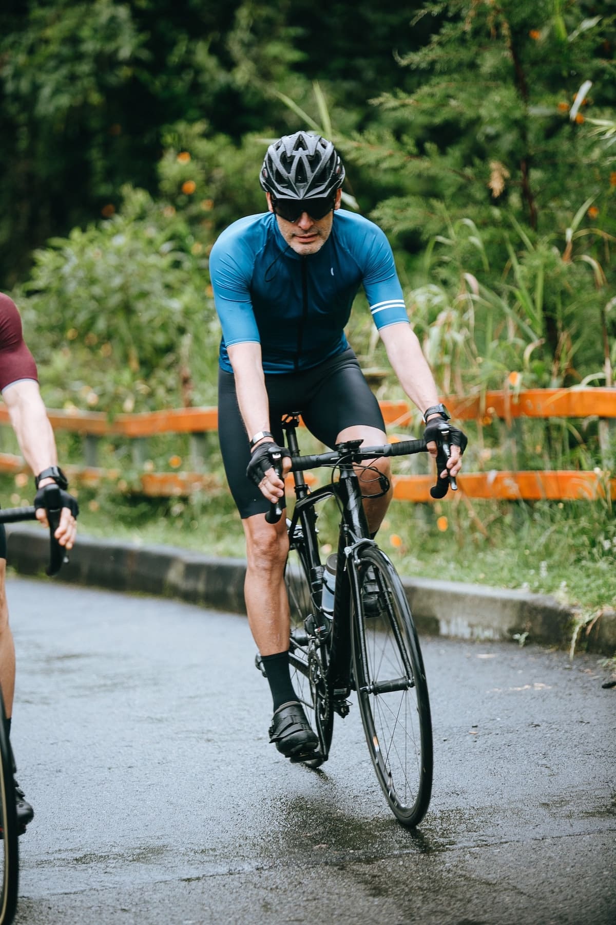 A cyclist wearing black shorts and a teal jersey.
